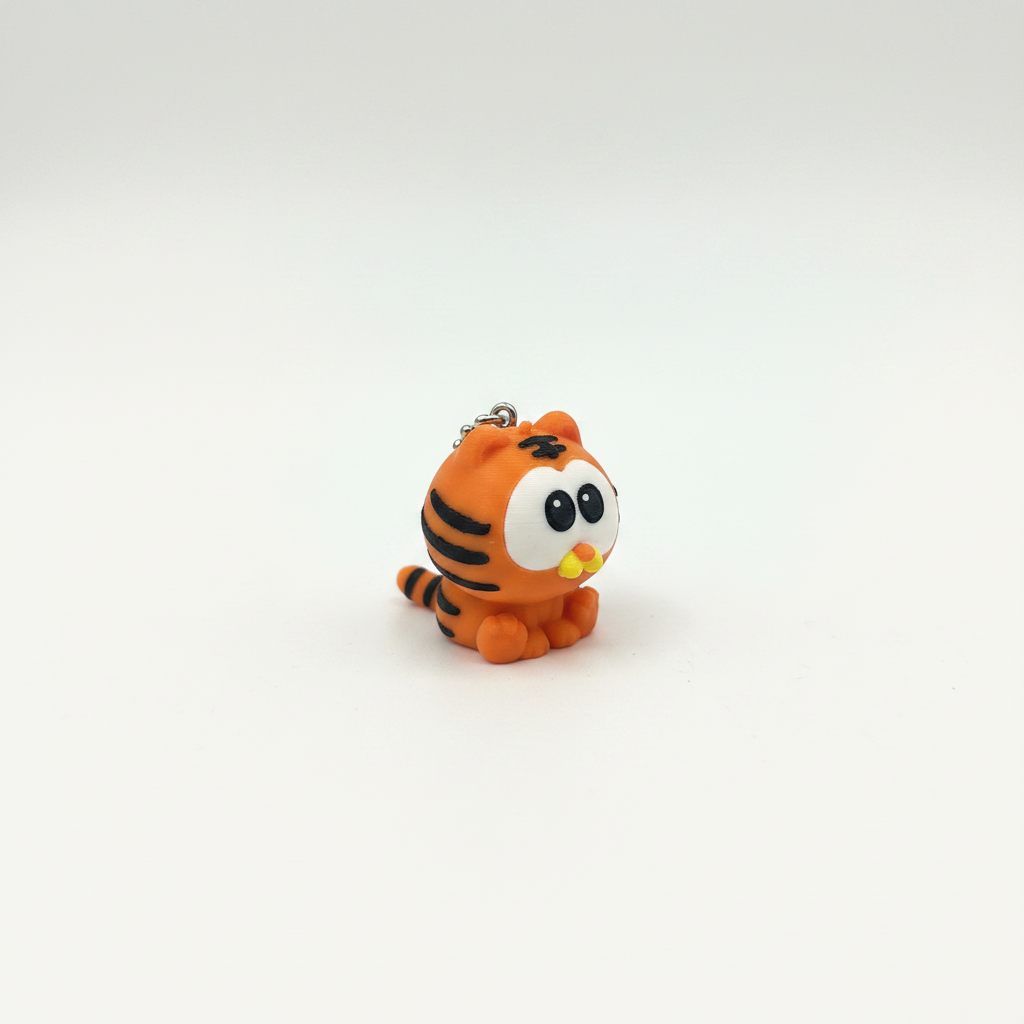 3D printed orange tiger cat keyring figurine on white background