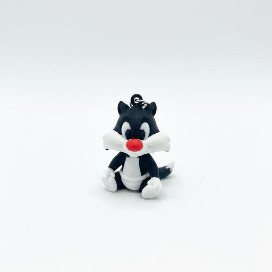 3D printed black and white cat keyring figurine on white background